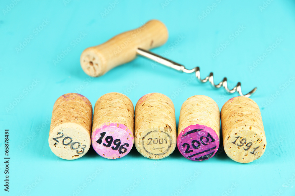 Wine corks with corkscrew on wooden table close-up