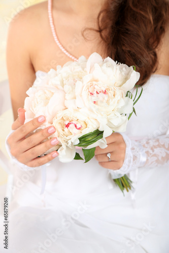 Bride holding wedding bouquet of white peonies  close-up 