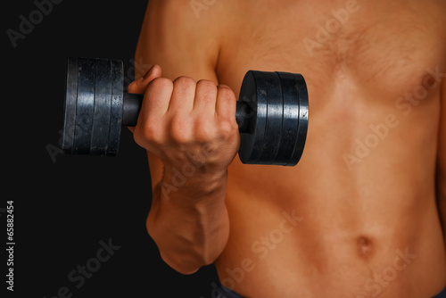Strong man is lifting dumbbell