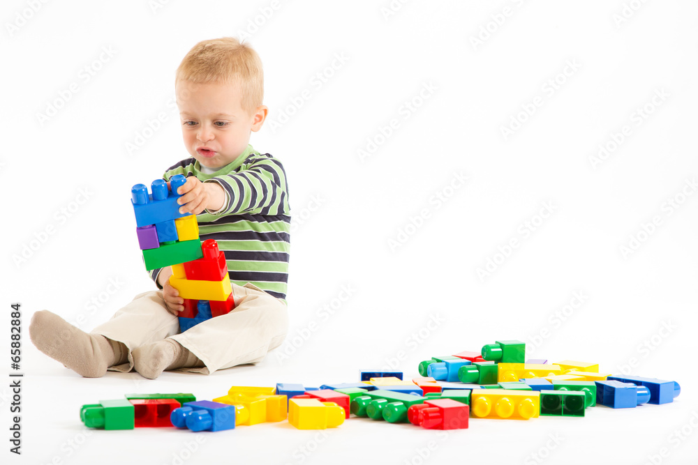 Little cute boy playing with building blocks. Isolated on white. Little cute boy playing with building blocks. Isolated on white.