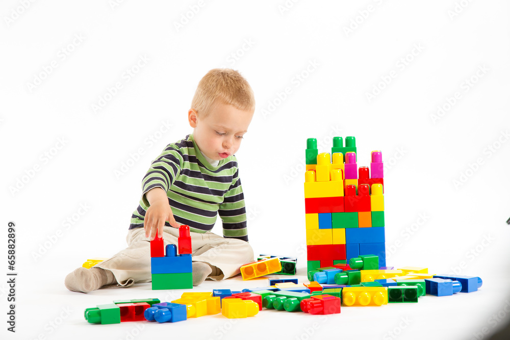 Little cute boy playing with building blocks. Isolated on white. Little cute boy playing with building blocks. Isolated on white.