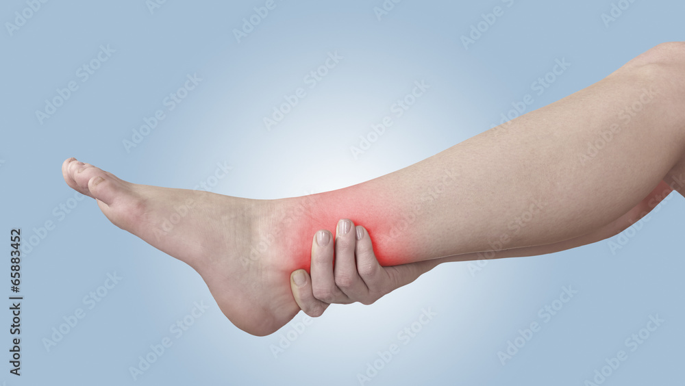 Acute pain in ankle. Woman holding hand to spot of ankle-aches. Acute pain in ankle. Woman holding hand to spot of ankle-aches.