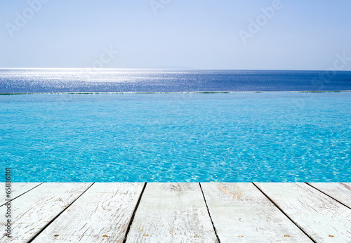 Infinity swimming pool and empty wooden plank