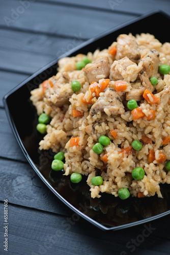 Vertical shot of pilaf with chicken on a black glass plate