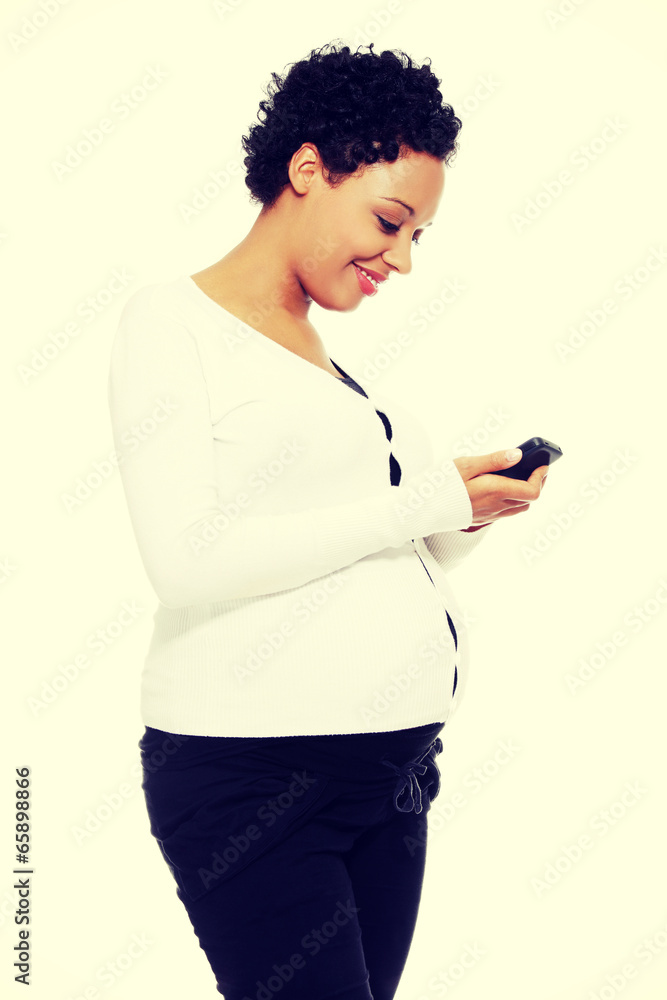 Beautiful pregnant woman dialing a number Beautiful pregnant woman dialing a number