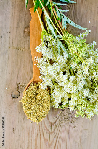 Herbal tea from meadowsweet in spoon on board