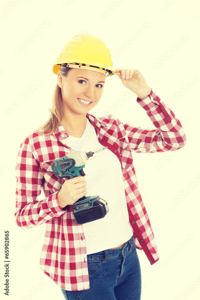 Woman holding drill and wearing safety helmet. Woman holding drill and wearing safety helmet.