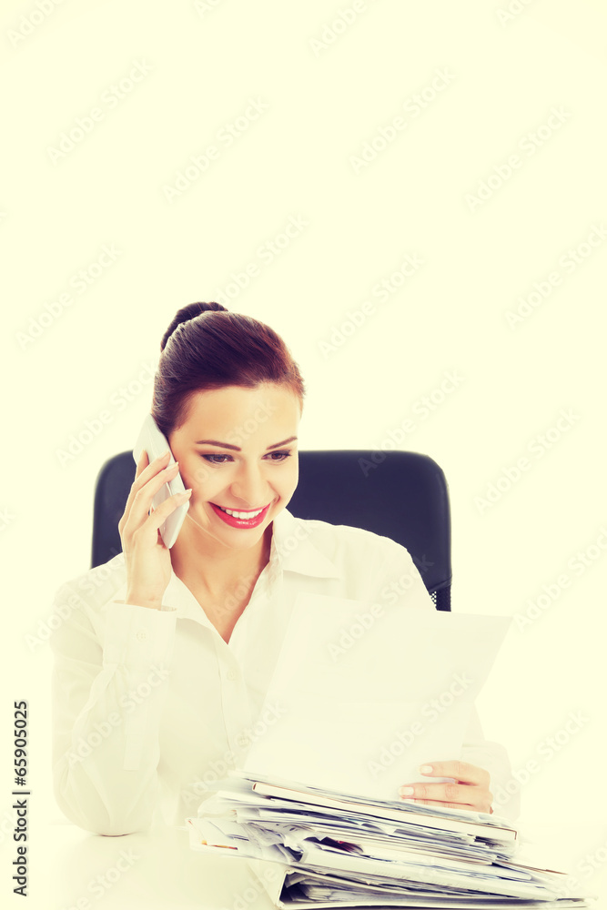 Businesswoman sitting and talking through phone. Businesswoman sitting and talking through phone.