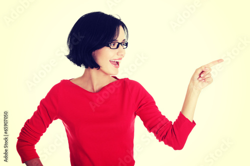 Excited young woman pointing on copy space