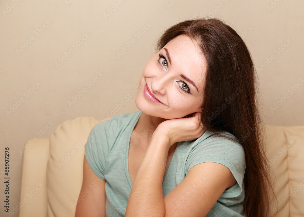 Beautiful smiling woman sitting on the sofa at home Beautiful smiling woman sitting on the sofa at home