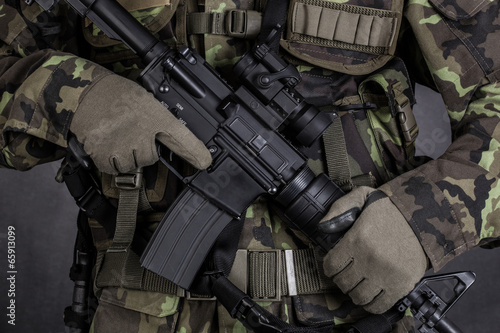Detail of a soldier holding modern weapon M4