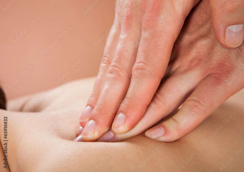Therapist Massaging Female Customer's Back At Spa