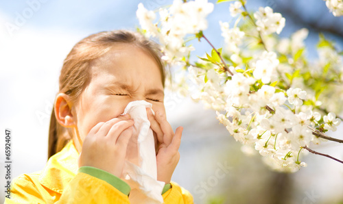 Little girl is blowing her nose