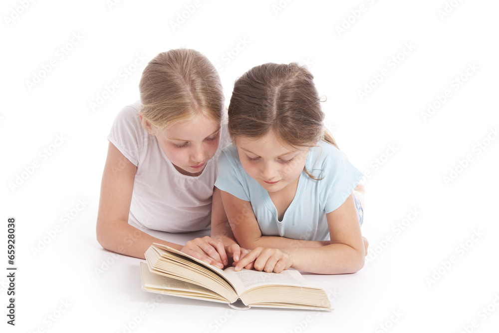 two young girls reading a book together two young girls reading a book together
