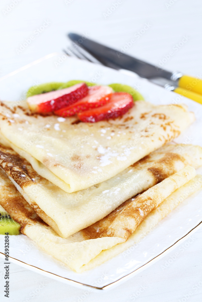 Delicious pancakes with strawberries and chocolate