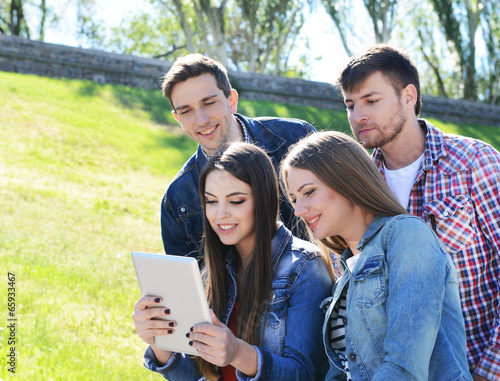 Happy students sitting in park