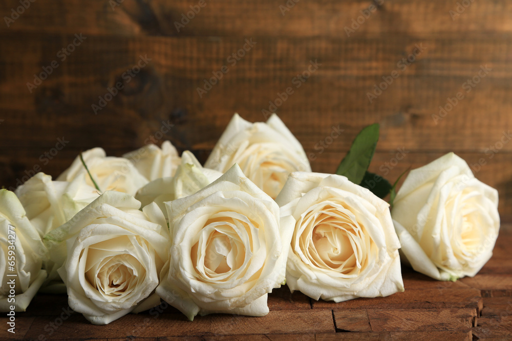 Obraz premium Beautiful white roses on wooden table