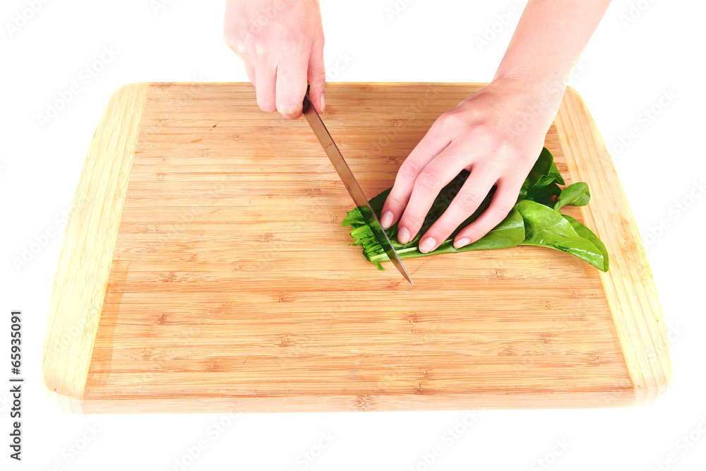 Female hand cutting greens on cutting board isolated on white Female hand cutting greens on cutting board isolated on white