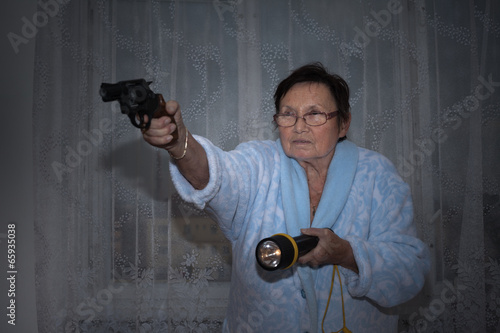 Senior woman with a gun and torch