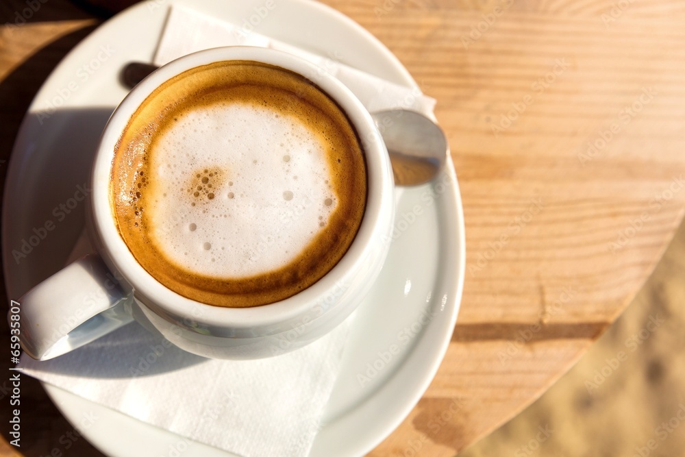 Morning cup of coffee,on the wooden table.