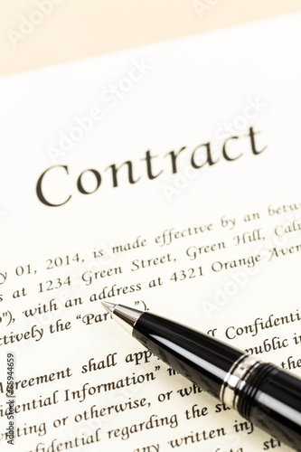 Business contract document on cream color paper focus at pen