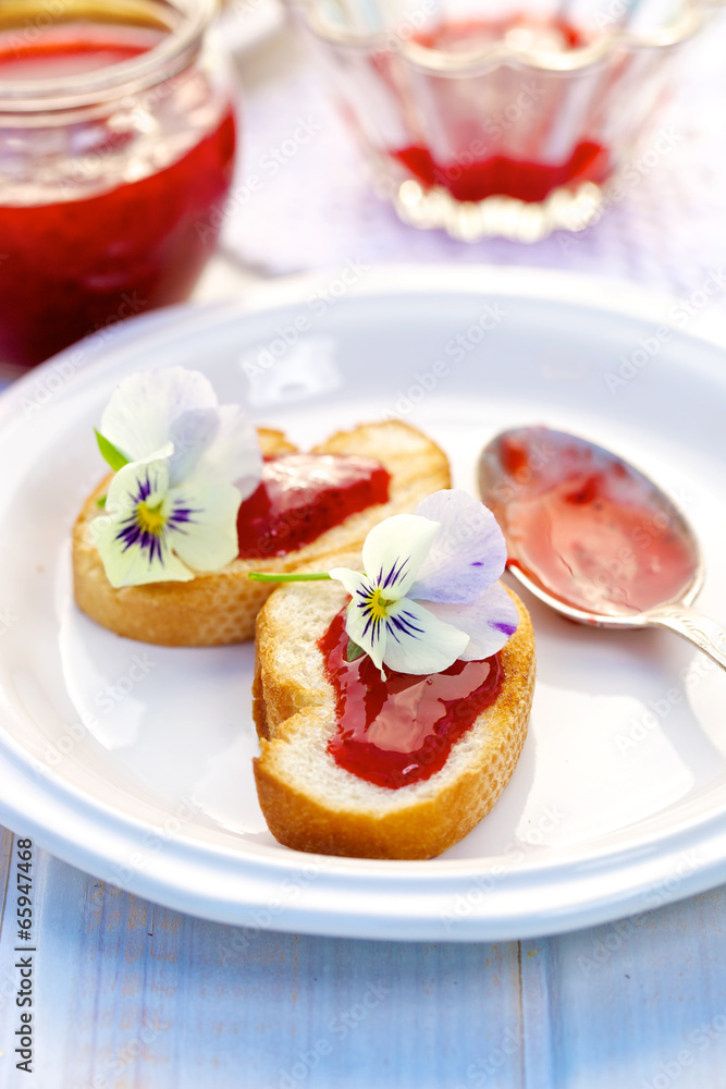 Toasts with homemade strawberry jam and edible flowers