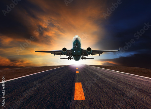Canvas Print passenger jet plane flying over airport runway against beautiful