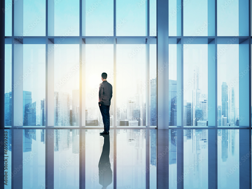 Businessman looking city through window Businessman looking city through window