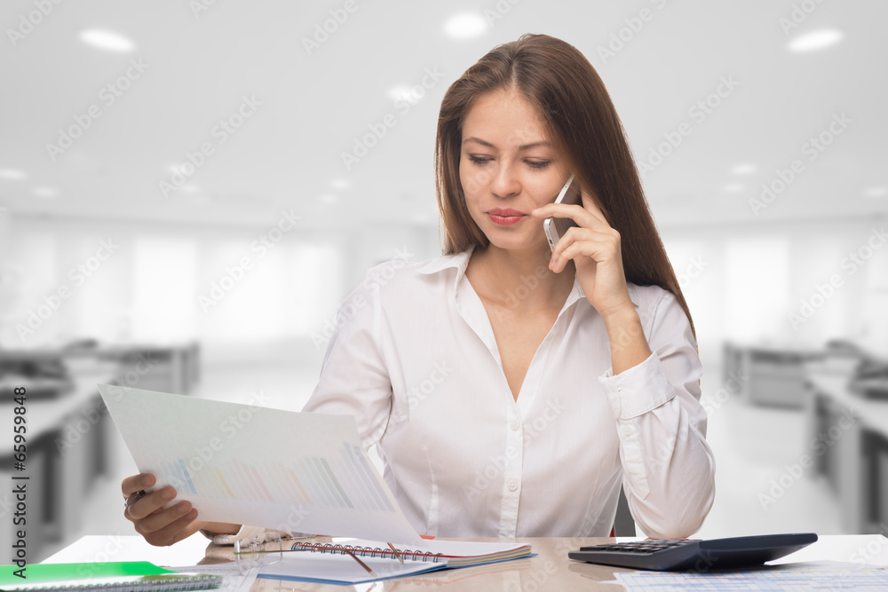 Businesswoman talking on the phone at the office Businesswoman talking on the phone at the office