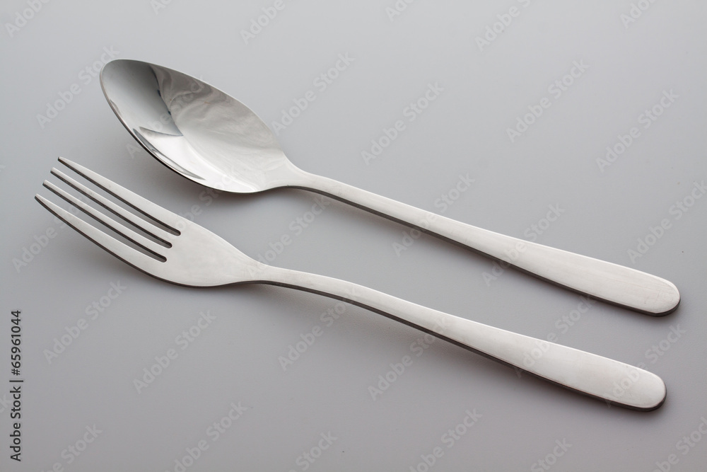 a silver fork with spoon isolated on gray background a silver fork with spoon isolated on gray background