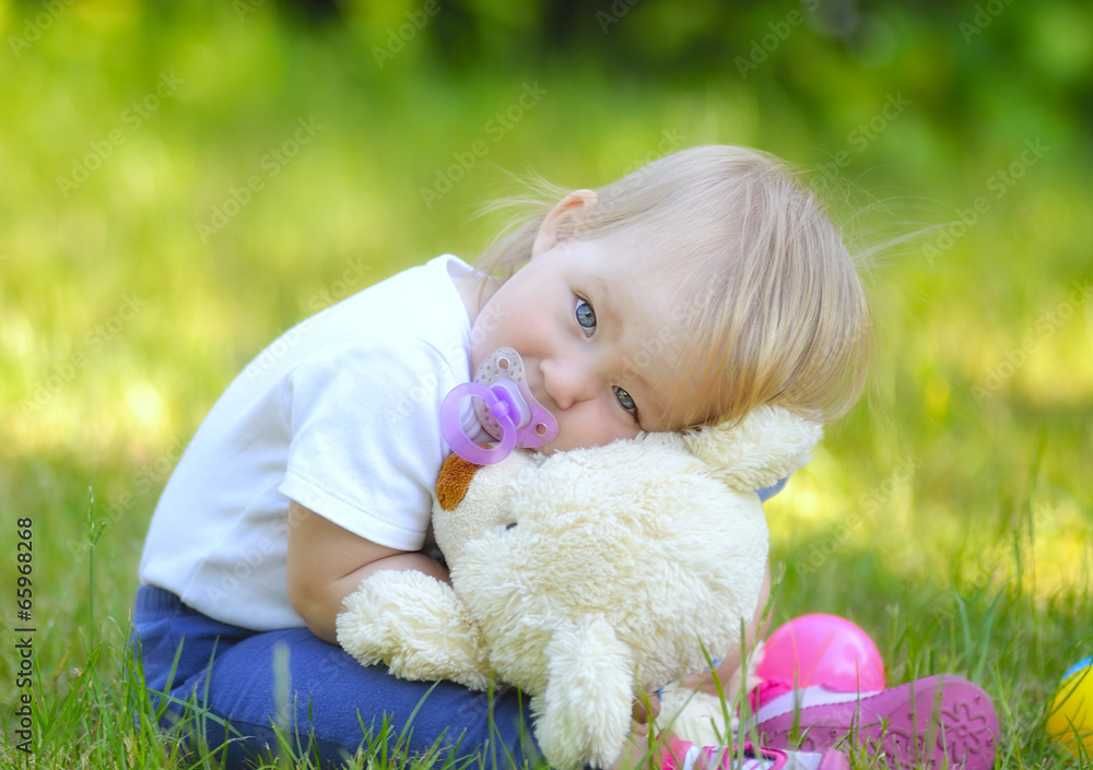 Cute baby with blue eyes hugging a mascot.