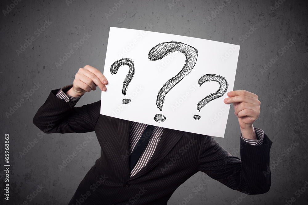 Businessman holding a paper with question marks in front of his Businessman holding a paper with question marks in front of his
