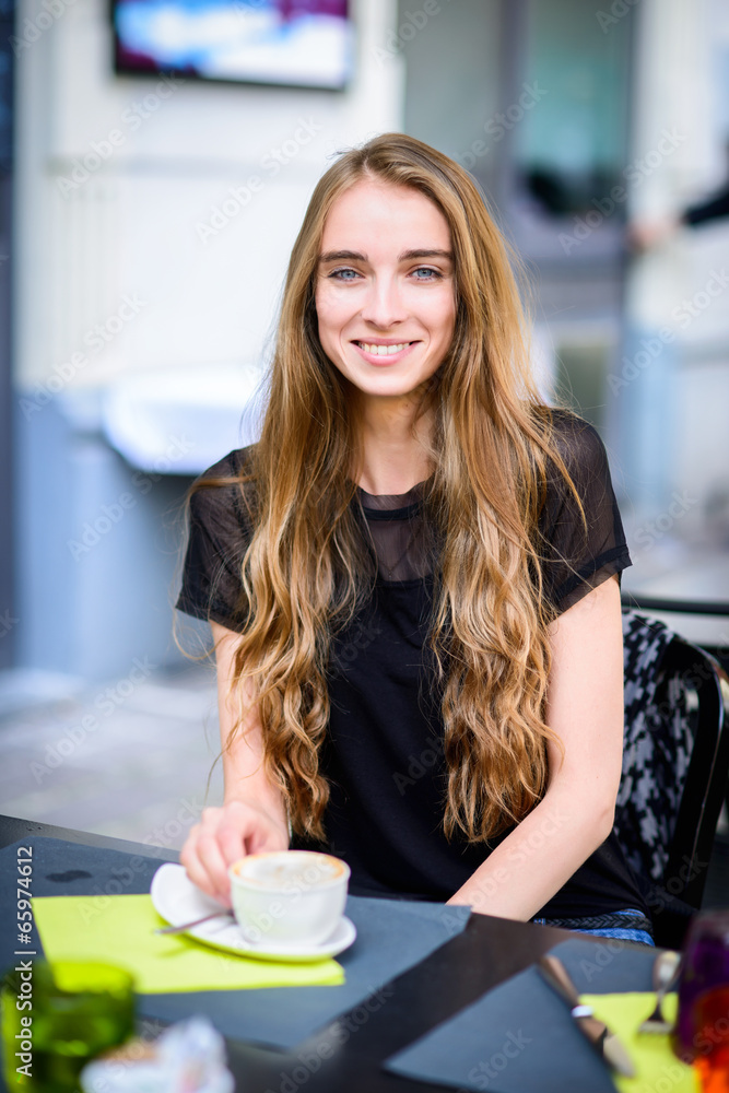 Beautiful smiling woamn drinking coffee at the street cafe Beautiful smiling woamn drinking coffee at the street cafe