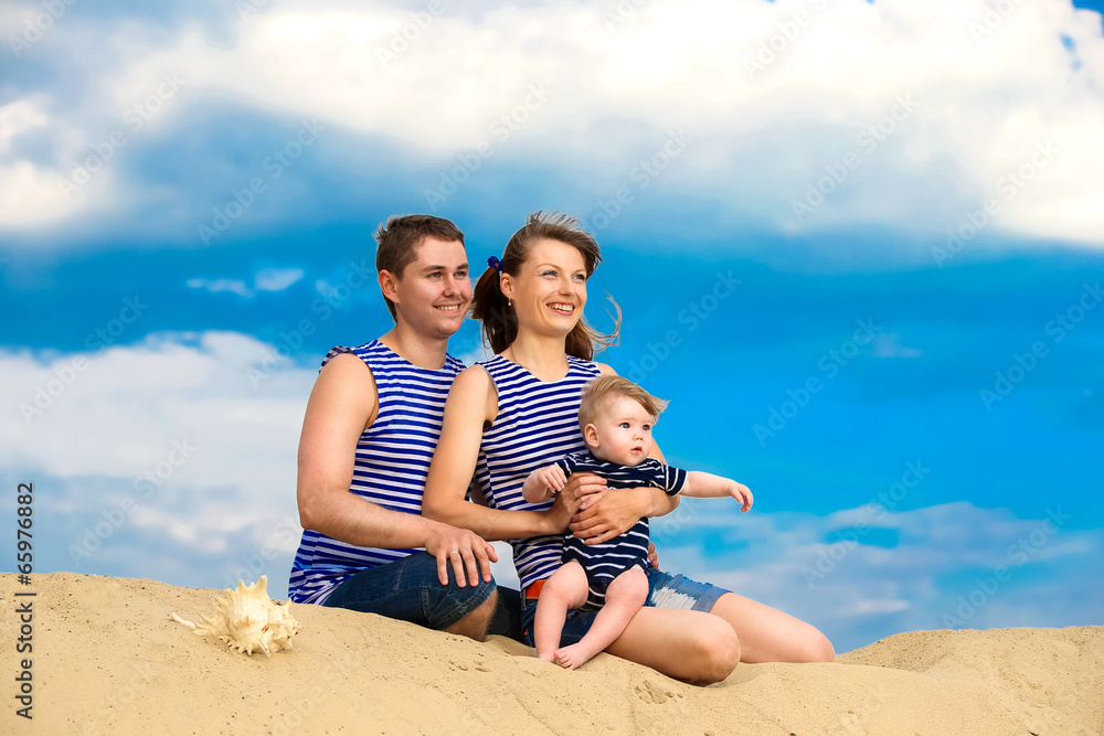 Happy family, mom, dad and little son in striped vests having fu Happy family, mom, dad and little son in striped vests having fu