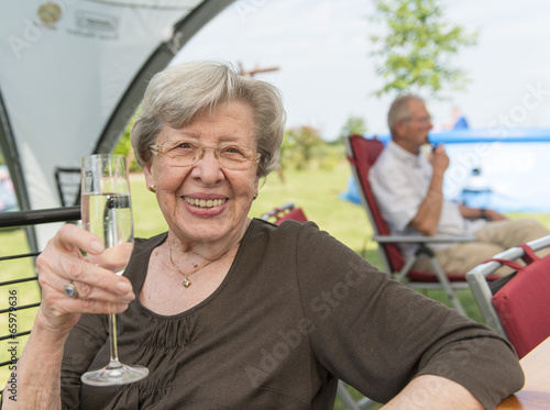 Senior Woman Outdoors in the Summer with Glass of Champagne