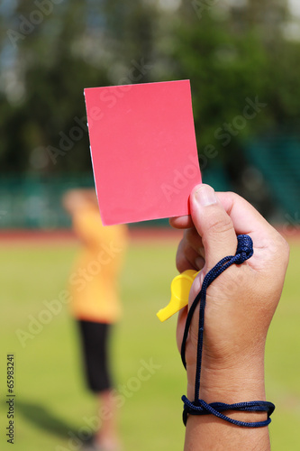 Hand of referee with red card and whistle photo