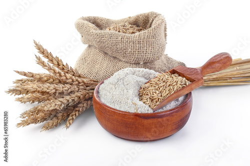 whole grain flour in a bowl and linen bag with a wooden spatula