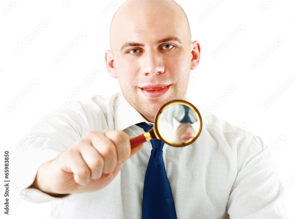 Young business man looking through magnifier Young business man looking through magnifier
