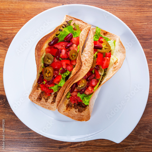 Mexican tacos in tortilla shells with fresh vegetables