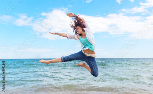 beautiful girl jumping on a background of sea and sky
