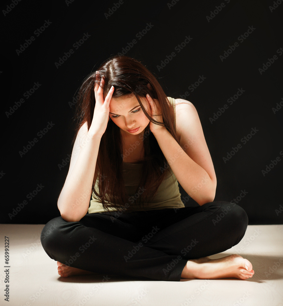Depressed woman sitting on floor with eyes closed Depressed woman sitting on floor with eyes closed