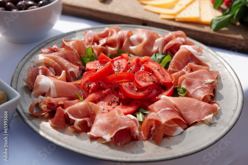 Platter with cured ham on table