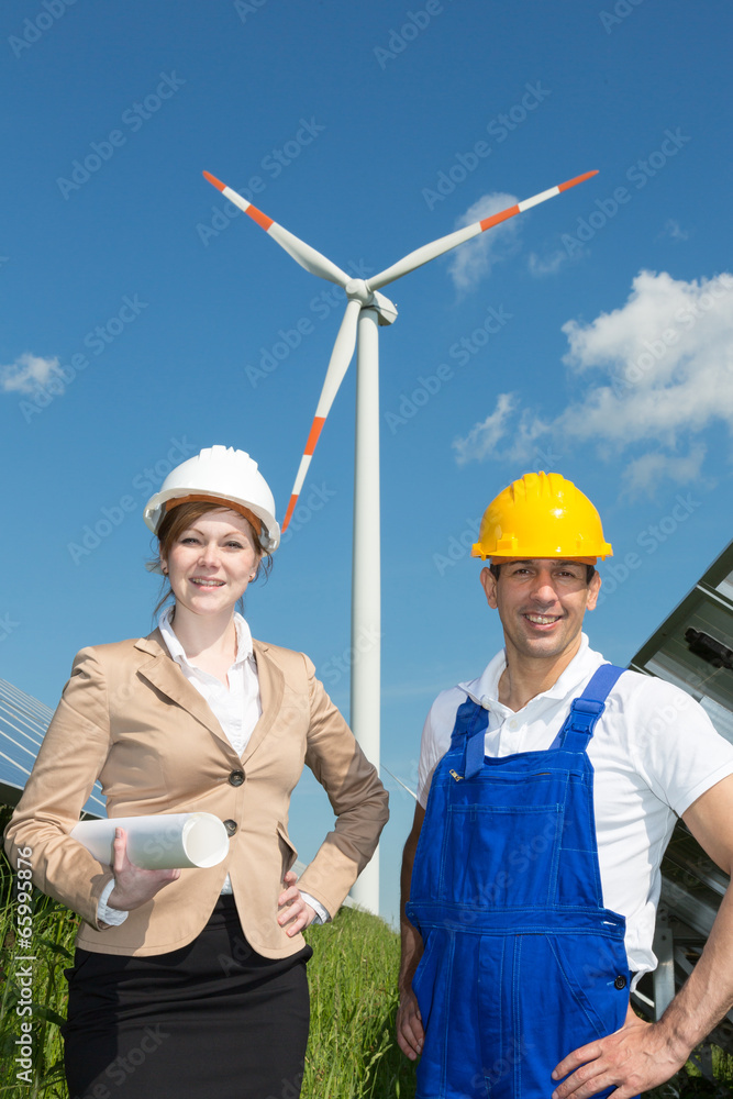 Engineer and contractor posing in front of wind turbine Engineer and contractor posing in front of wind turbine