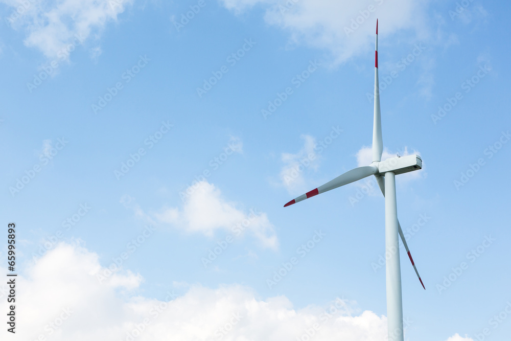 A wind turbine in front of blue sky with clouds A wind turbine in front of blue sky with clouds