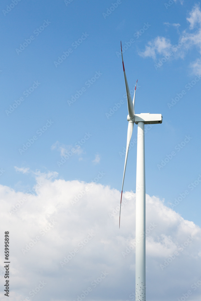 A wind turbine in front of blue sky with clouds A wind turbine in front of blue sky with clouds
