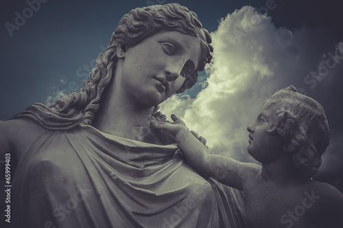 Woman and child Greek sculptures over clouds background