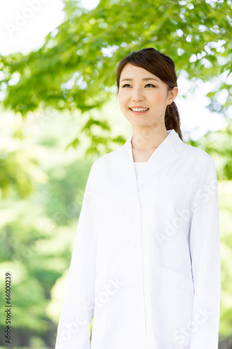 young asian doctor relaxing on green background