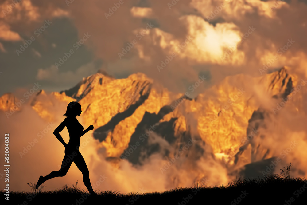 Silhouette of a woman running jogging in the mountains at sunset
