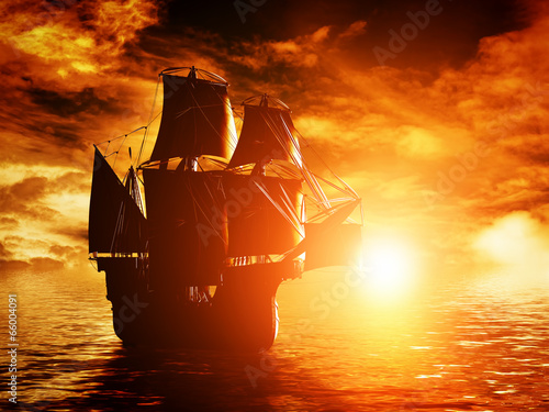 Ancient pirate ship sailing on the ocean at sunset