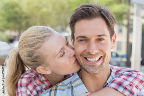 Foto Young hip woman giving boyfriend kiss on the cheek